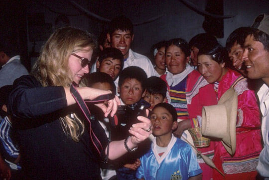 Pamela Coulston with Peruvian children, showing camera.