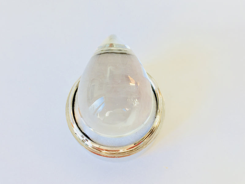 Very large colourless tear-drop shape white topaz gem, white background in gem jar.