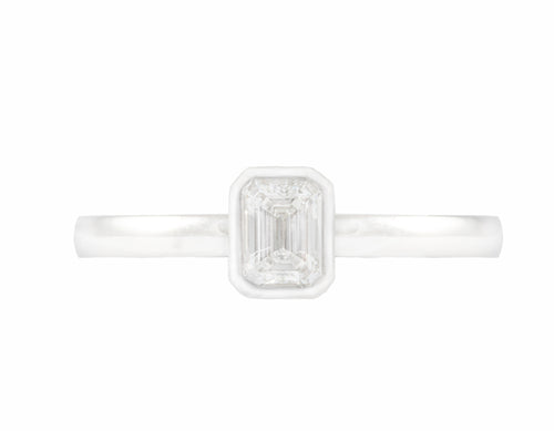 Thin platinum ring set with an octagon cut diamond. Gem is frame or bezel set and sits above the band.