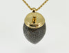 Very long pear shaped gem mottled grey and black with yellow gold cap and chain.
