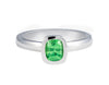 Platinum ring set with a bright apple green tsavorite garnet.  Gem is set in a frame, bezel, rising above the band.