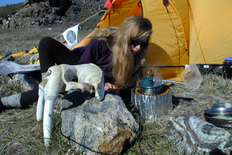 Pamela Coulston in front of tent, walrus skull, coffee, camp stove, Pond Inlet, Nunavut