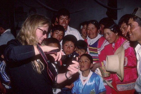 Pamela Coulston with Peruvian children, showing camera.