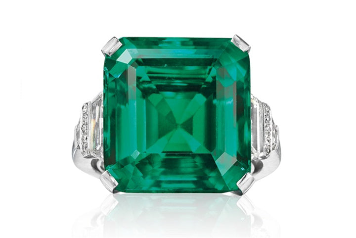 Very large Emerald with diamonds in ring.