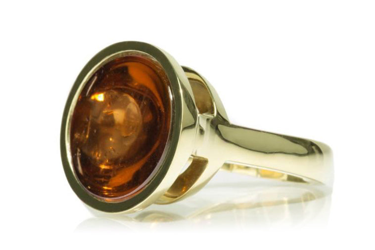Deep golden brown gem in green gold ring.