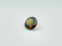 Caramel, brown, green Andalusite gem, round.
