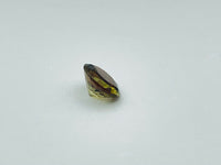 Caramel, brown, green Andalusite gem, round.