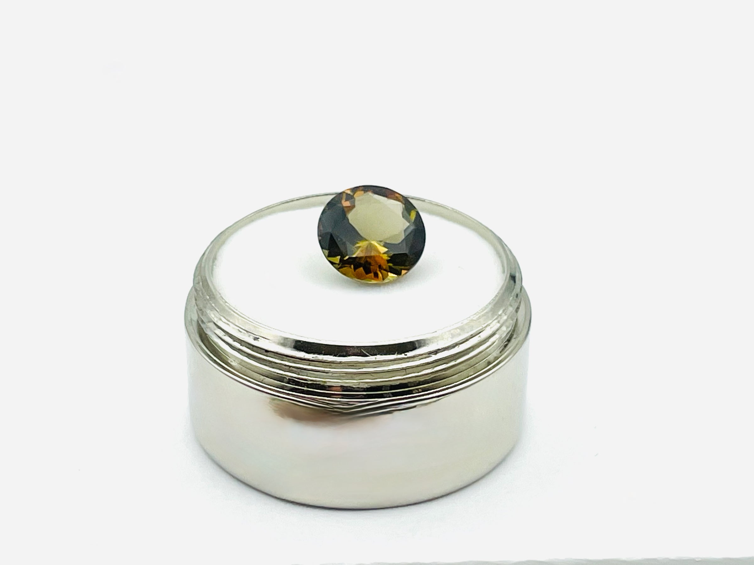 Caramel, brown, green Andalusite gem, round. 