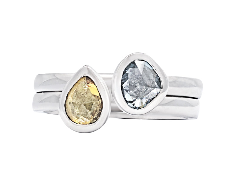 Two platinum rings with yellow and blue sapphires.