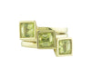 Three green gold rings set with square green peridot gems.