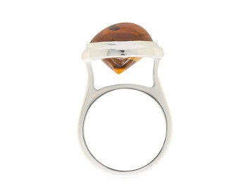 Large silver ring with oval orange gem.
