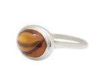 Large silver ring with oval orange gem.