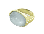 Large green gold ring with overlapping ribbon of gold around the band set with rectangle cabochon of aquamarine. Gem lies across the finger.