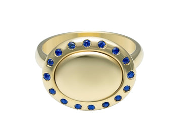 Small oval signet ring with a halo or small sapphires all around edge of face in green 18k gold.