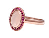 Small oval signet ring with a halo or small rubies all around edge of face in rose 18k gold.