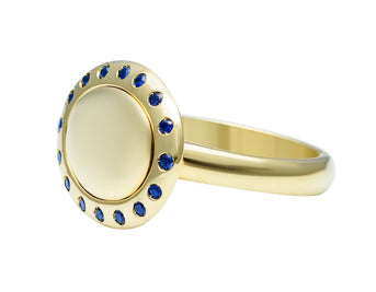 Small oval signet ring with a halo or small sapphires all around edge of face in green 18k gold.