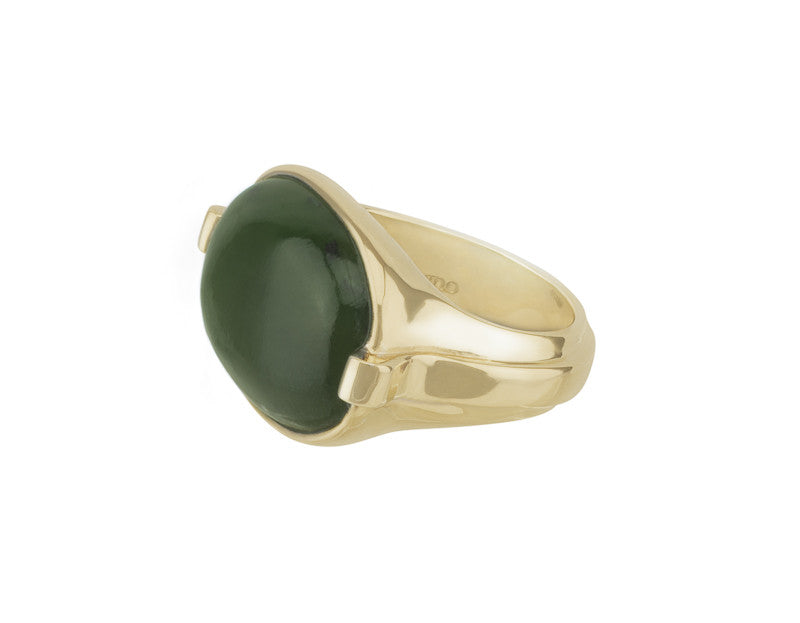 Green gold ring with overlapping ribbon of gold around the band set with rectangle cabochon of green jade. Gem lies across the finger.