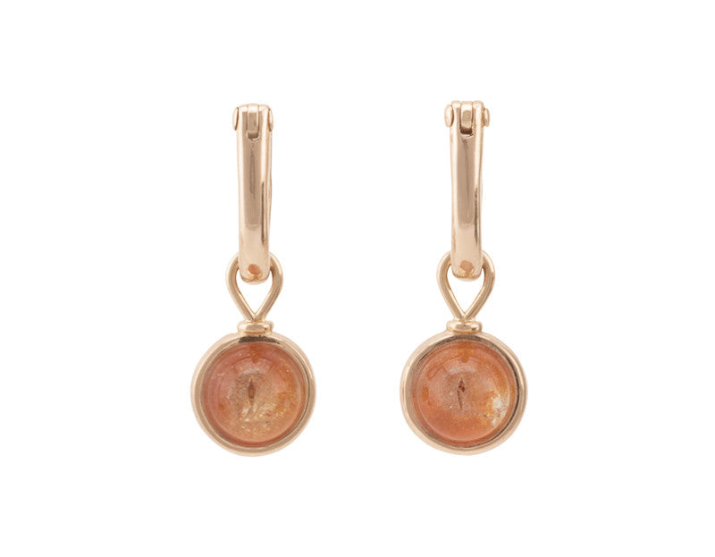 Round drops with bright orange cabochon gem in rose gold frame. Drops hang on small U shaped hoops in solid rose gold.