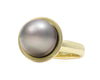 Green gold ring set with pear shaped grey pearl.