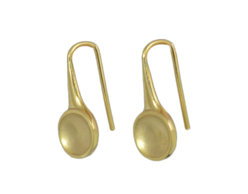 Oval drop earrings in yellow gold with matte finish in bowl, on shepherd's hooks.