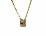 Rose gold bead shaped like spool of thread, on yellow gold chain