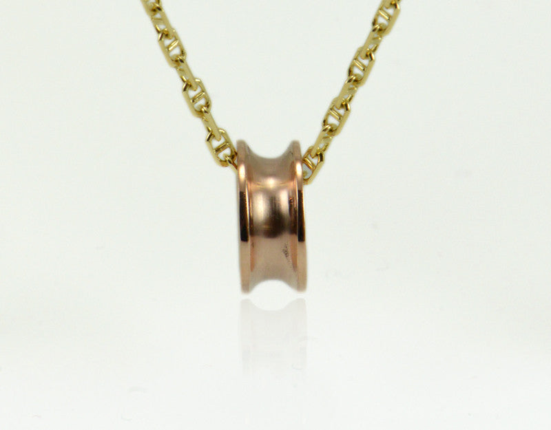 Rose gold bead shaped like spool of thread, on yellow gold chain