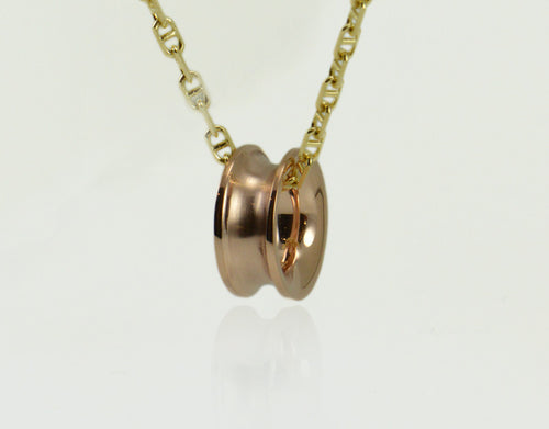 Rose gold bead shaped like spool of thread, on yellow gold chain