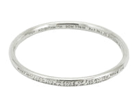 Silver bangle, round wire, with engraved text.