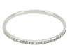 Silver bangle, round wire, with engraved text.