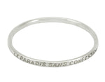 Silver bangle, round wire, with engraved text.