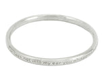 Silver bangle, round wire, with engraved text.