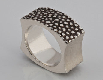 Wide silver band with blackening and texture. Concave sides.