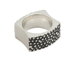 Wide silver band with blackening and texture. Concave sides.