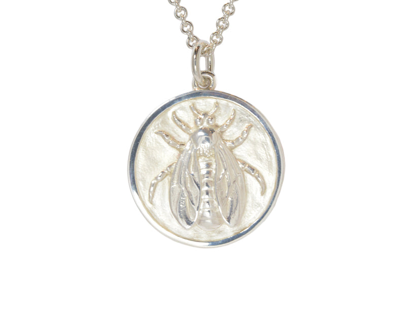 Very large silver pendant, round, with detailed bee carved in relief.  Hung on silver chain.
