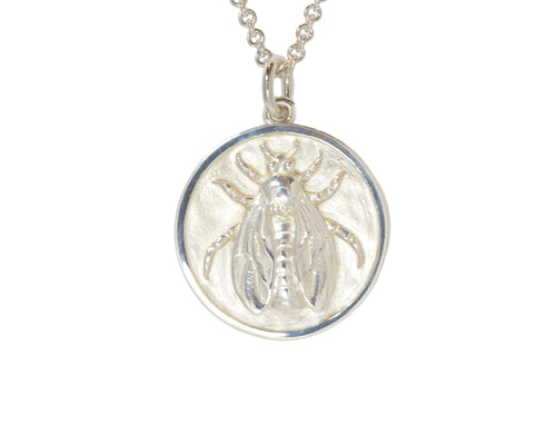 Very large silver pendant, round, with detailed bee carved in relief.  Hung on silver chain.
