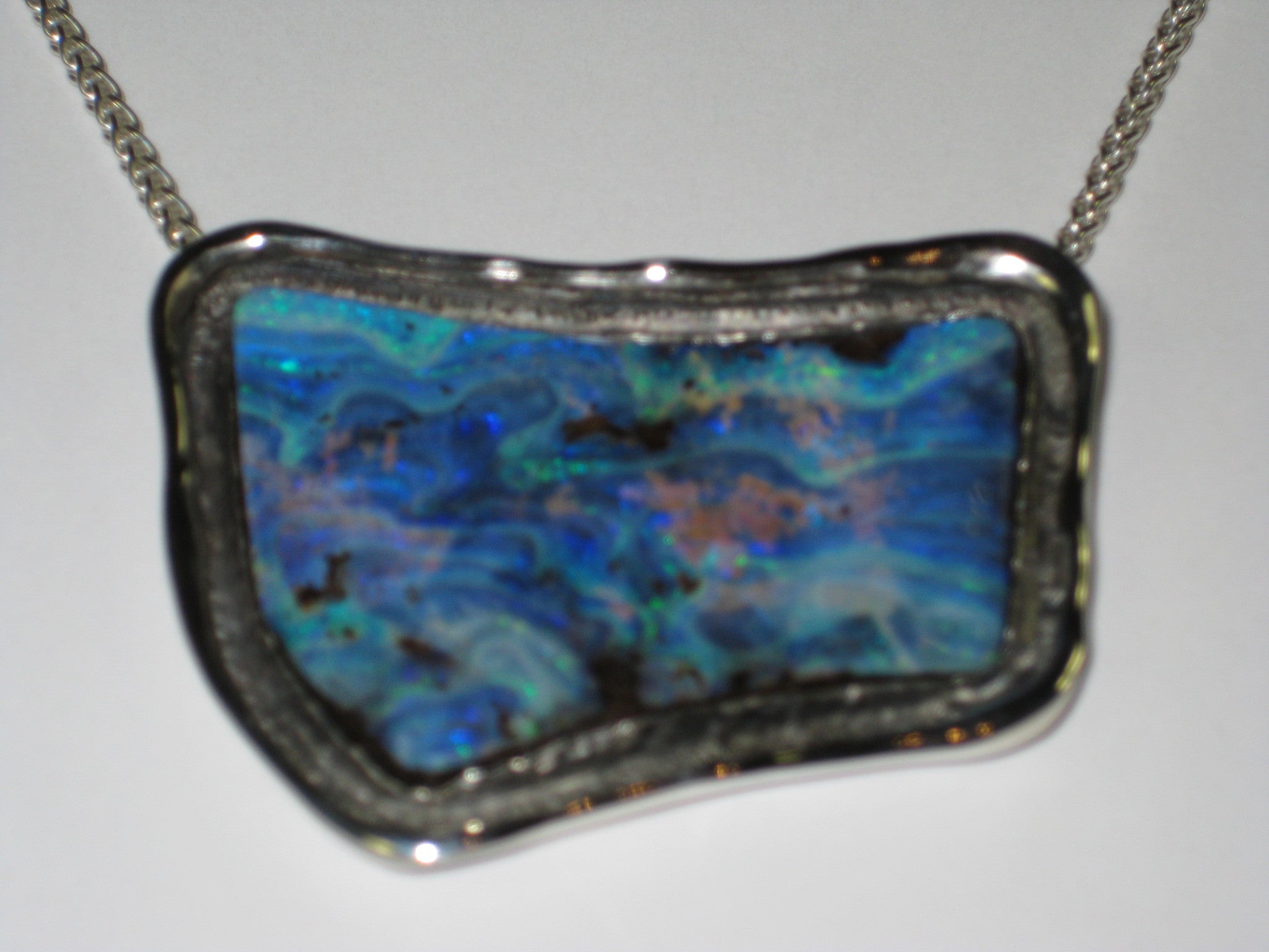 Free form blue opal in white gold pendant.