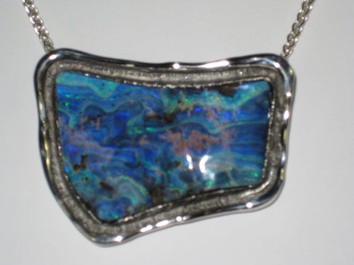 Free form blue opal in white gold pendant.