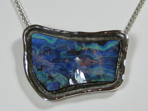 Free form blue opal in white gold pendant.