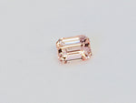 Small rectangular peach-pink sapphire gem, on white background.