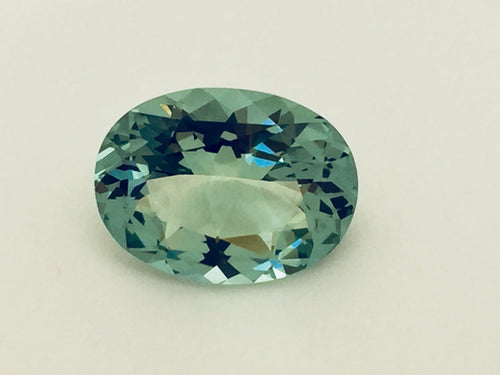 Large oval green beryl gem, on white background.