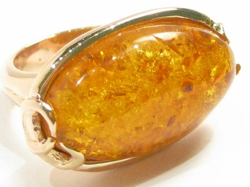 Very large oval amber set in rose gold ring.