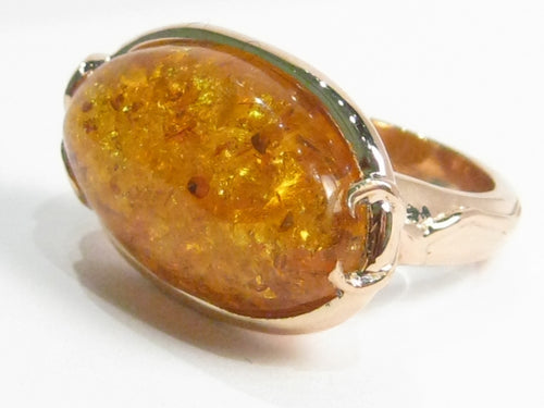 Very large oval amber set in rose gold ring.