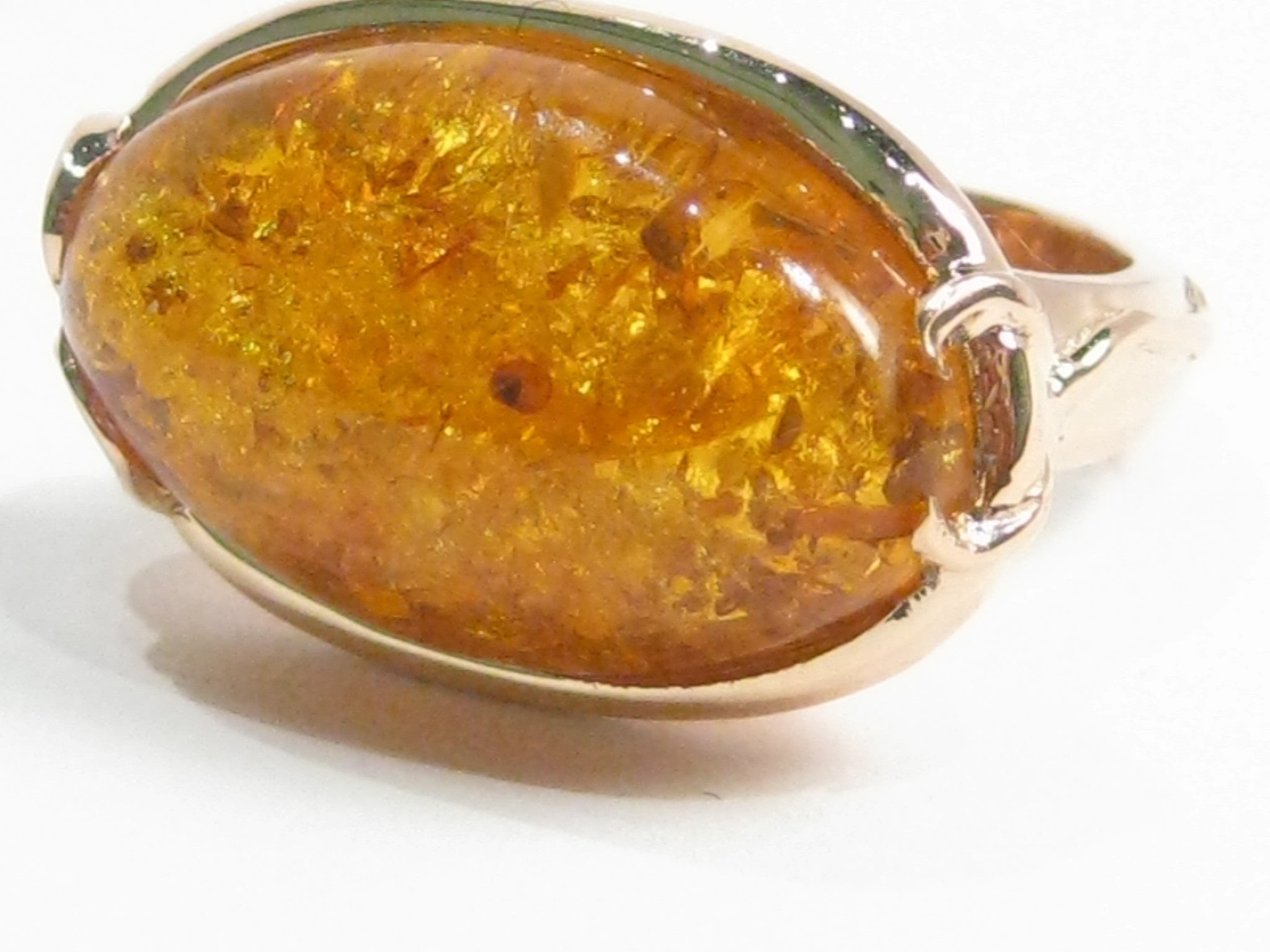 Very large oval amber set in rose gold ring.