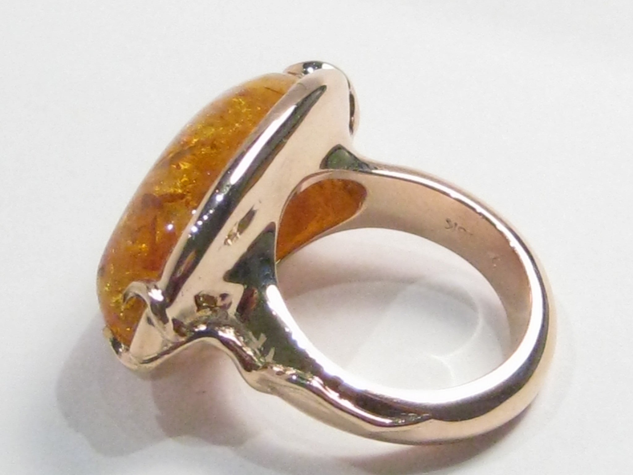Very large oval amber set in rose gold ring.