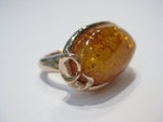Very large oval amber set in rose gold ring.