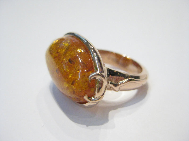 Very large oval amber set in rose gold ring.
