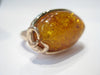 Very large oval amber set in rose gold ring.