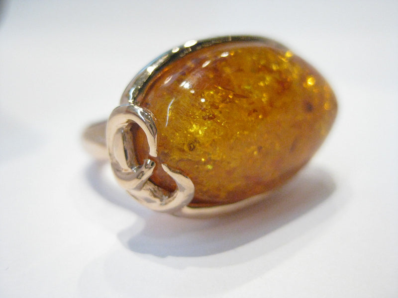 Very large oval amber set in rose gold ring.
