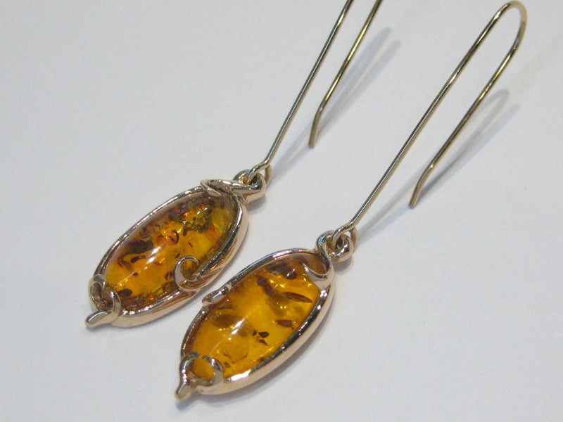 Pair of very large oval ambers set in rose gold earrings.