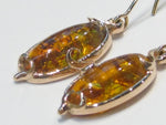 Pair of very large oval ambers set in rose gold earrings.
